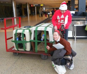 Inch arrives in Seattle on Christmas Eve greeted by Xan Blackburn (kneeling) of Team Inch and Moira Corrigan of GPI.